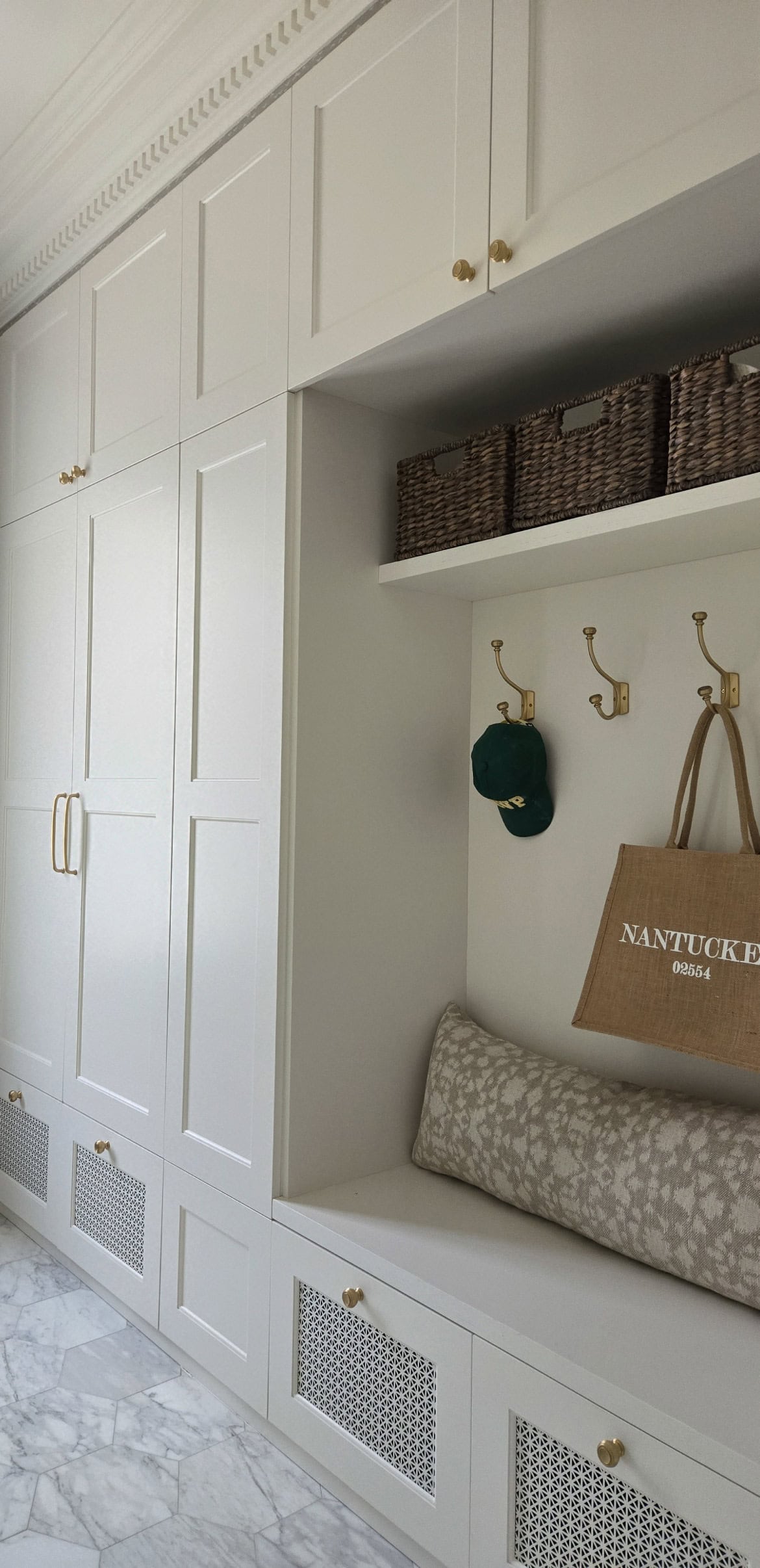 Floor to ceiling mudroom shelving with coat hooks and nook